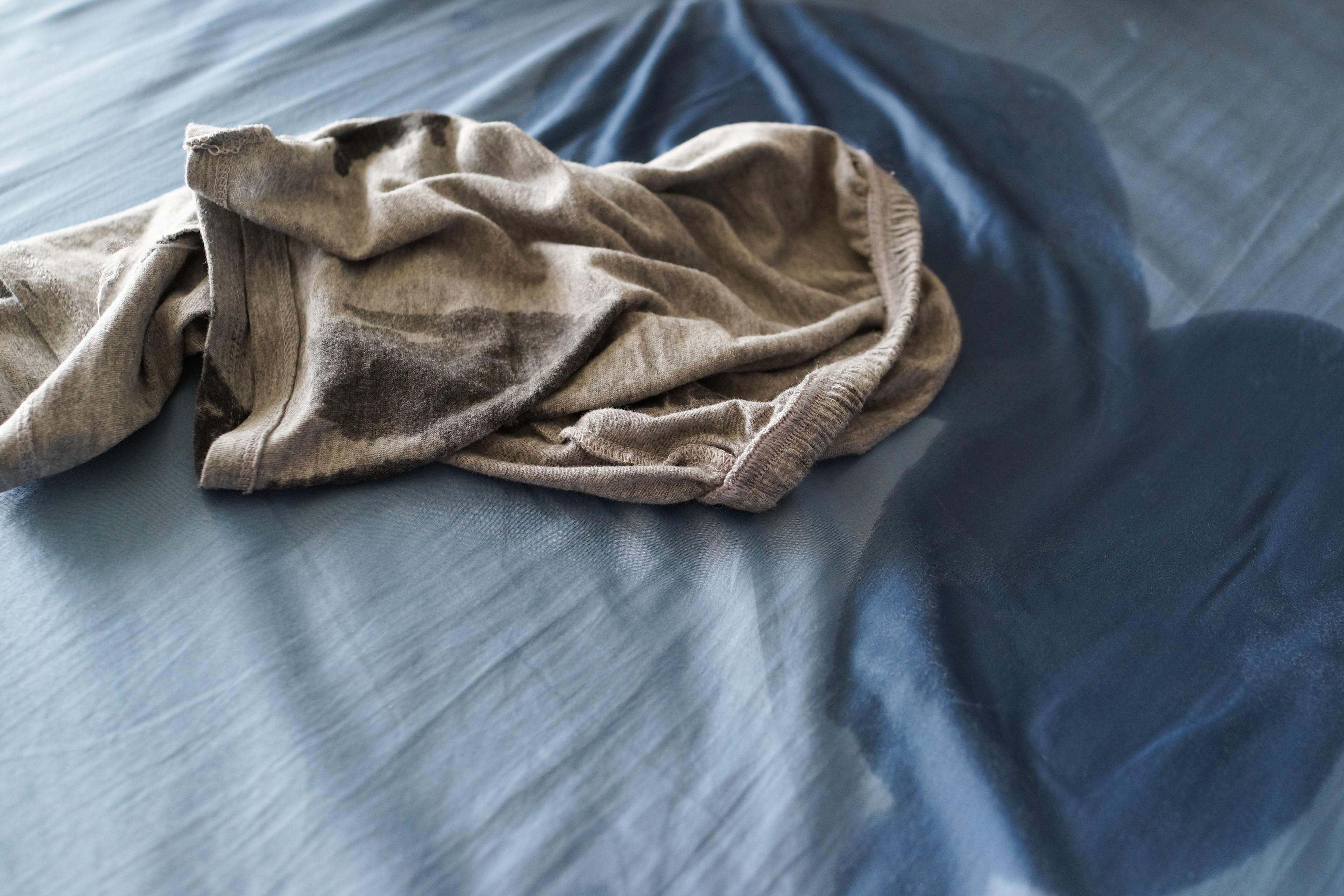En nerkissad säng med blöta pyjamasbyxor.