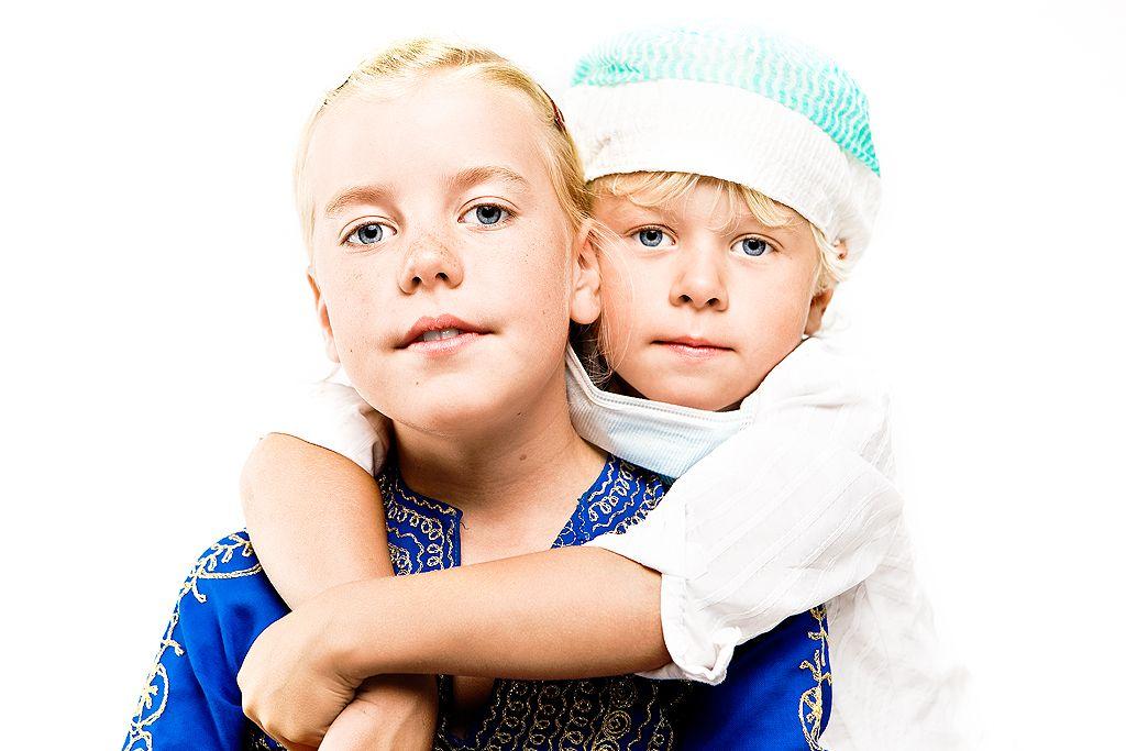 Boy in a surgical cap stands behind girl and hugs her.