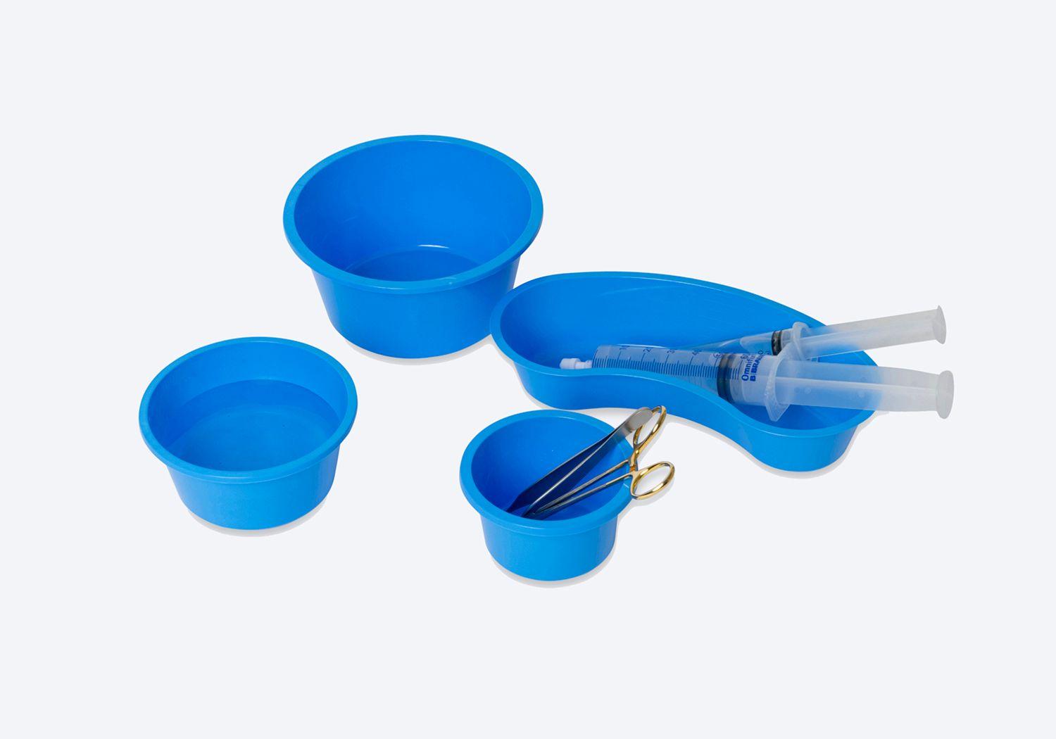 Tre blå, runda skålar med saxar och pincetter, och en blå oval skål med sprutor.