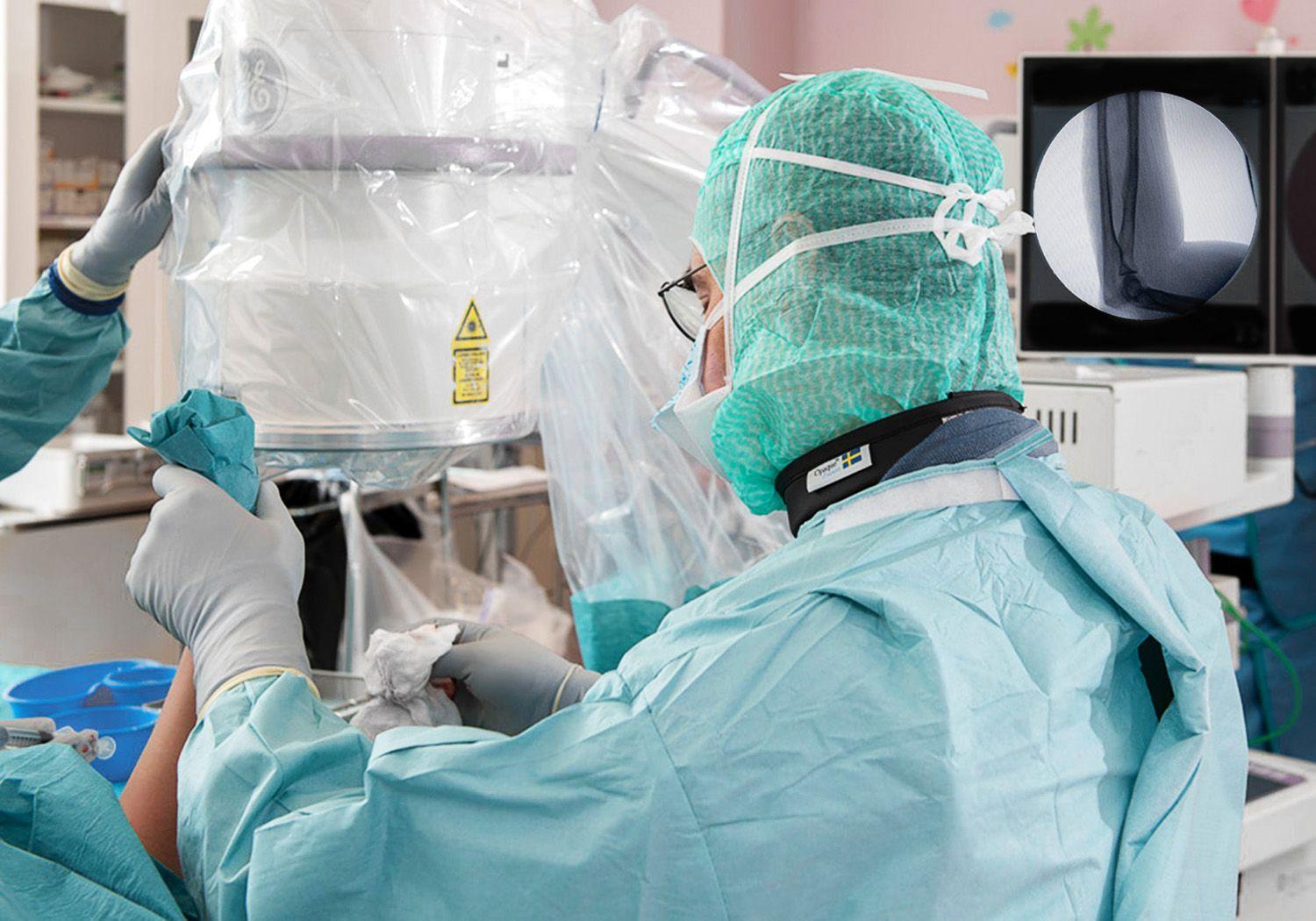 Läkare som opererar och röntgar en arm samtidigt som han opererar.