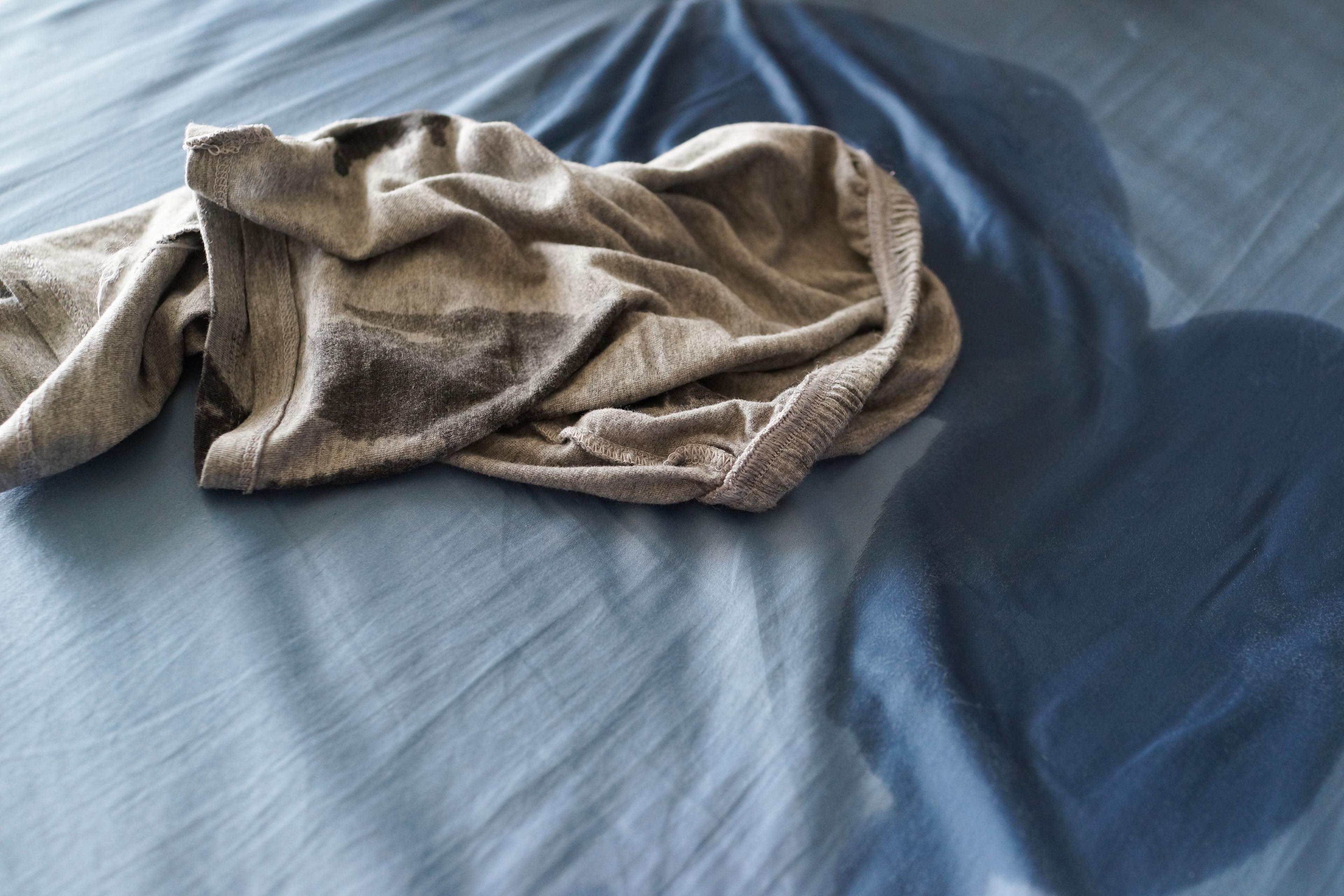 En nerkissad säng med blöta pyamasbyxor.
