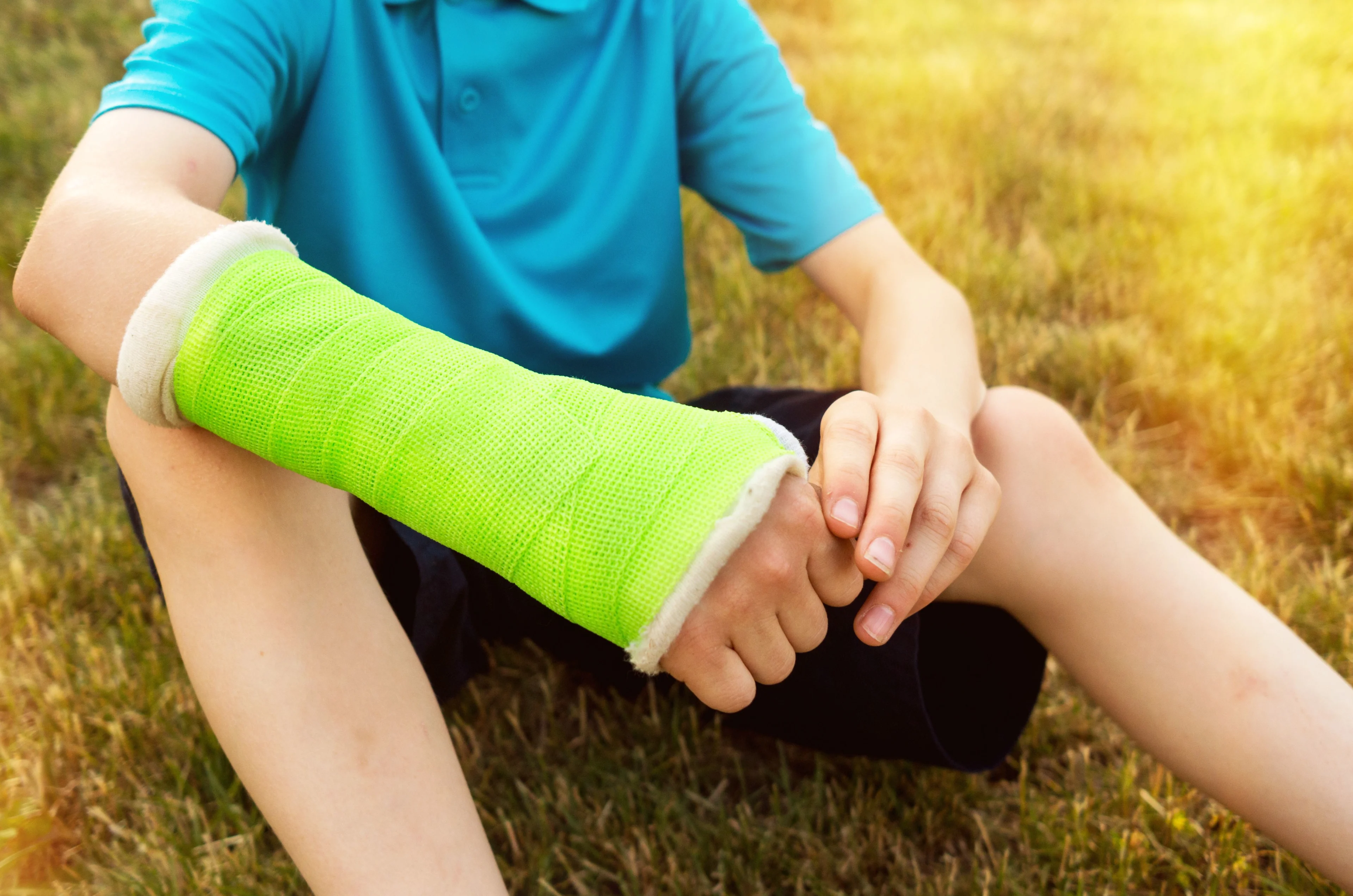 Grönt gips på armen på ett barn.