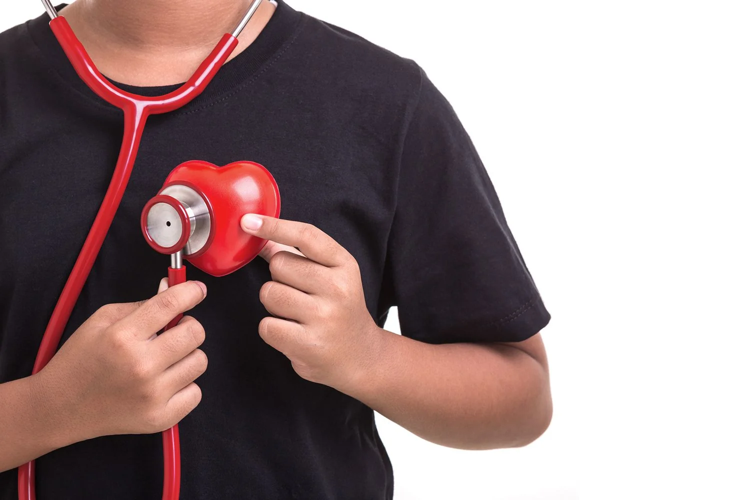 En pojke i svart t-shirt lyssnar på sitt eget hjärta med ett rött stetoskop.