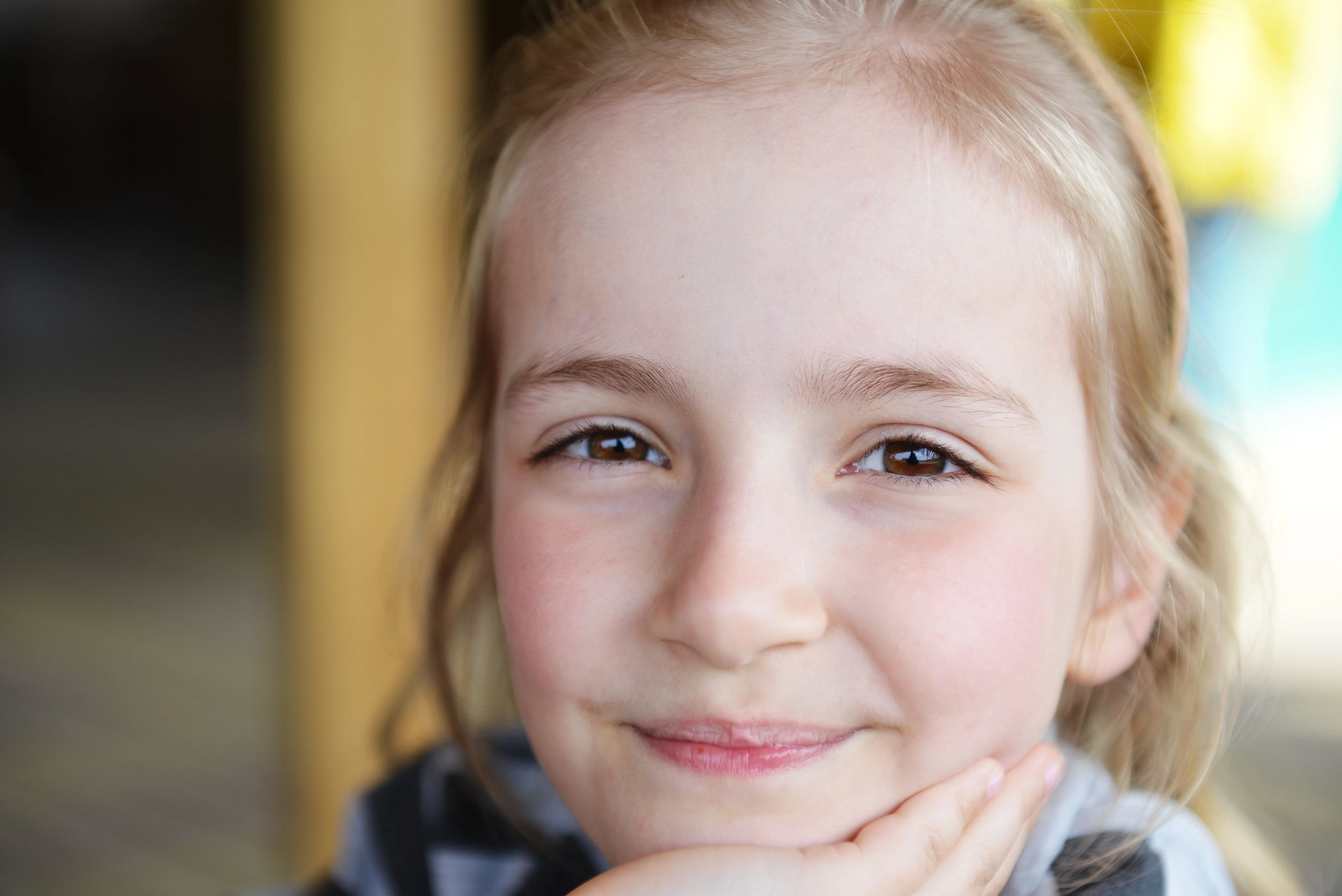 Tonårsflicka tittar in i kameran och ser nöjd ut.