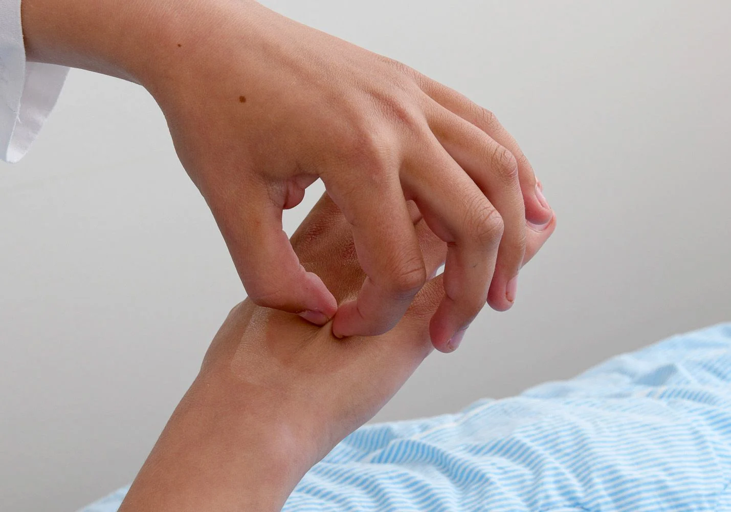 Flicka nyper på sin bedövade hand.