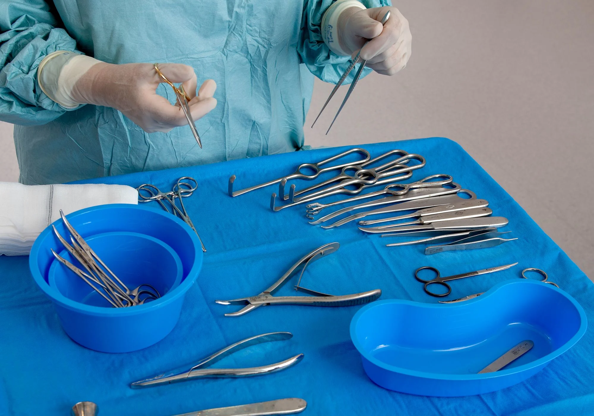 Bord med runda och ovala blå skålar med många operationsinstrument.