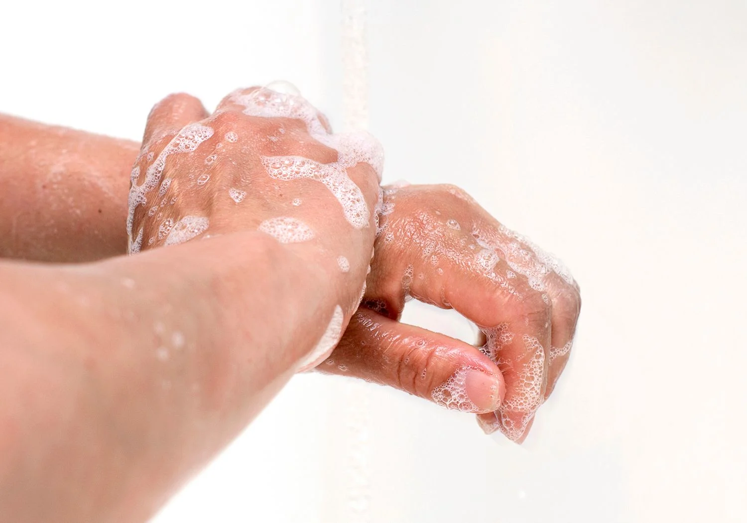 Doktor tvättar händerna med tvål som löddrar.