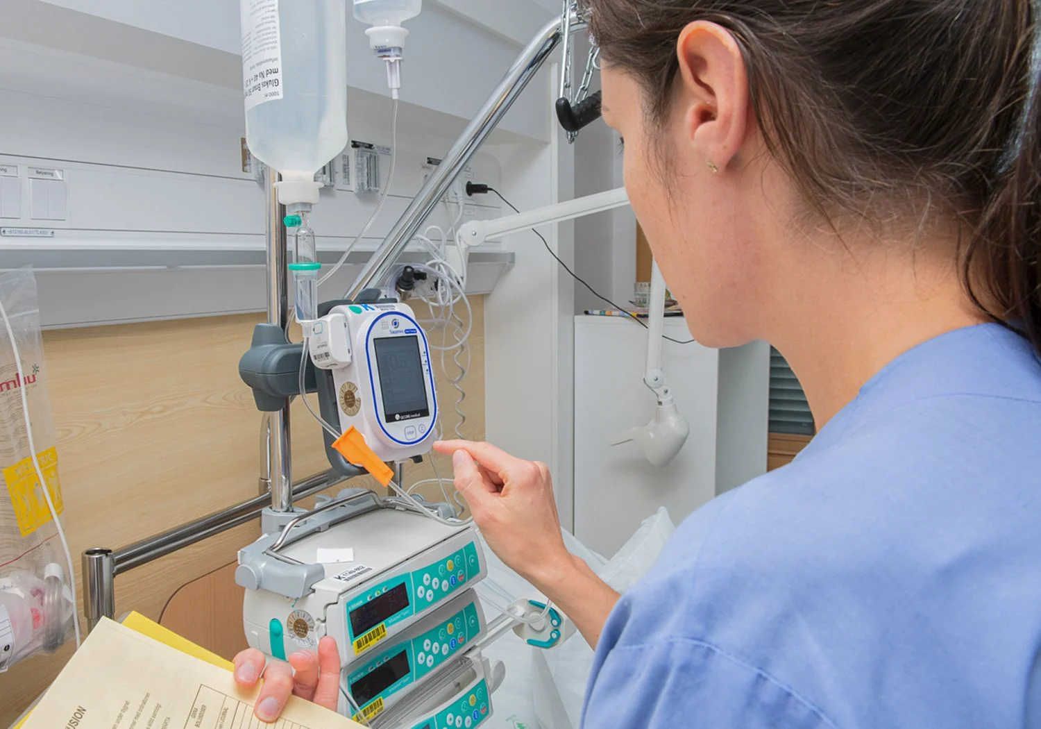 Sjuksköterska ställer in medicinpumpar.