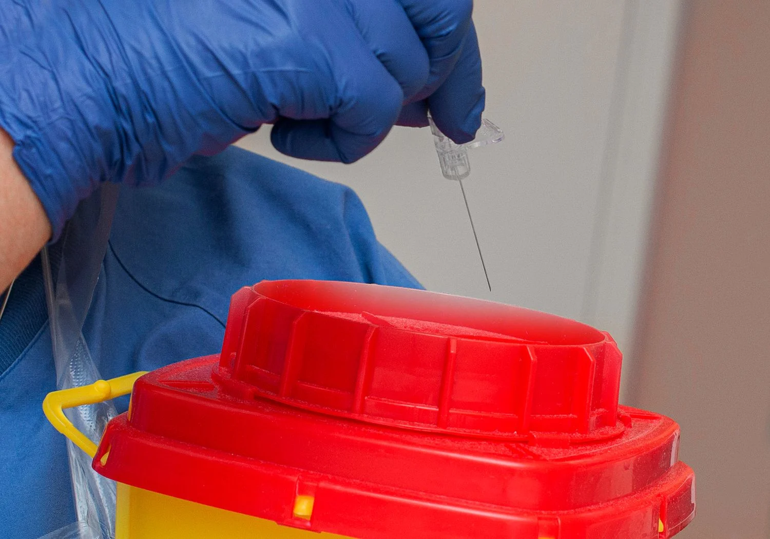 Sjuksköterskan slänger nålen hon stuckit med.