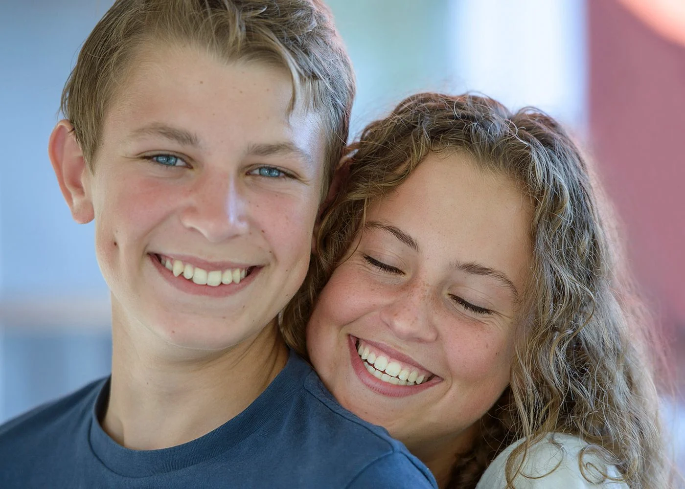 En tonårstjej och pojke ser glada ut.