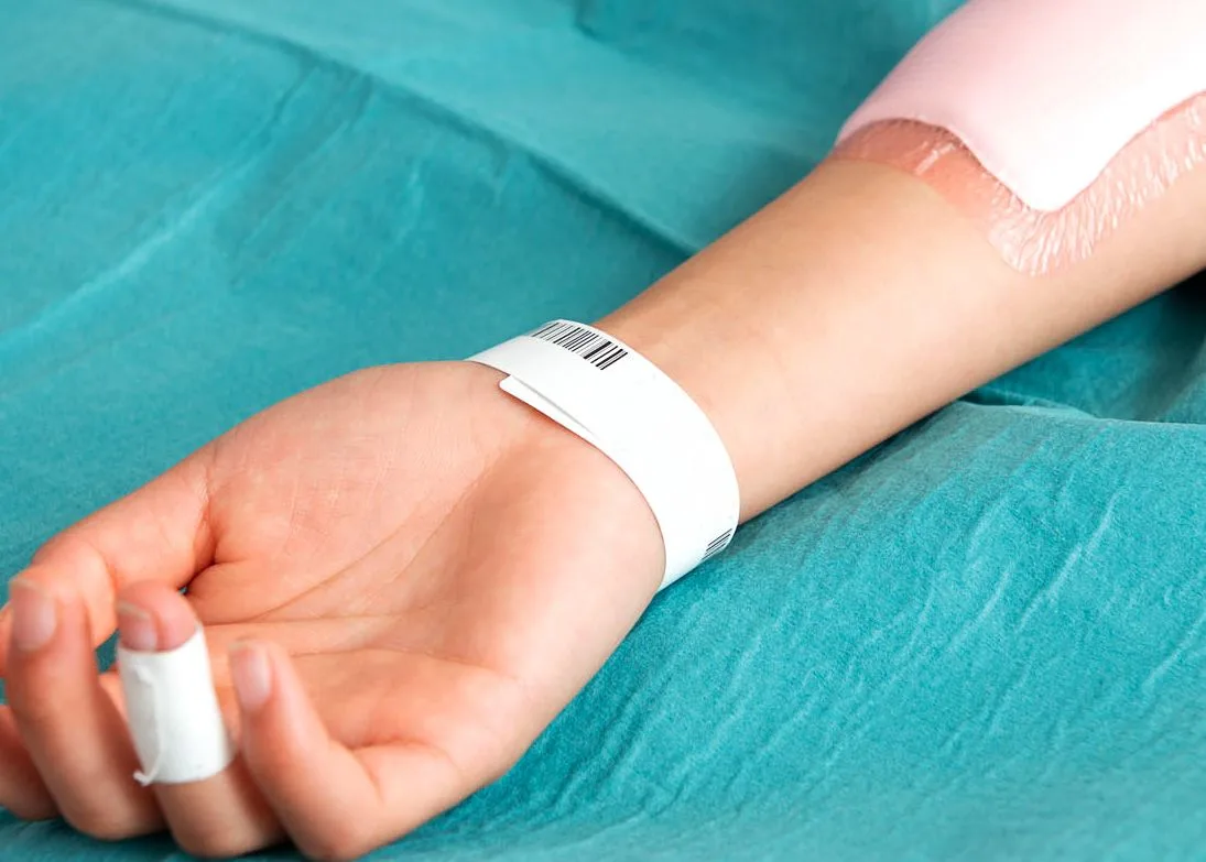 En arm med ett armband där det står 2003.